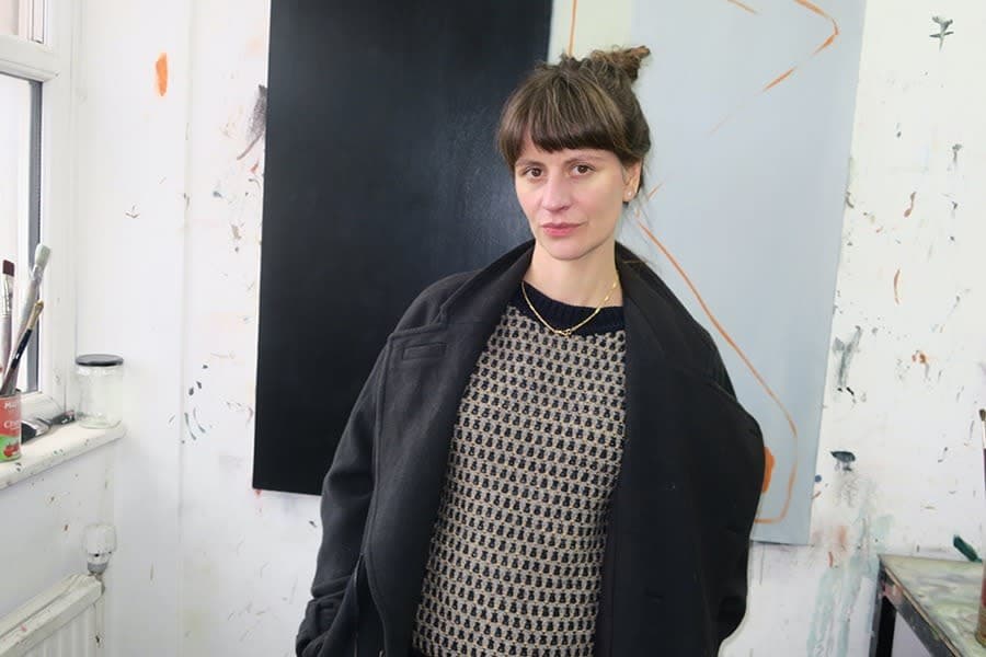 A portrait of artist Eve Ackroyd stood in the studio