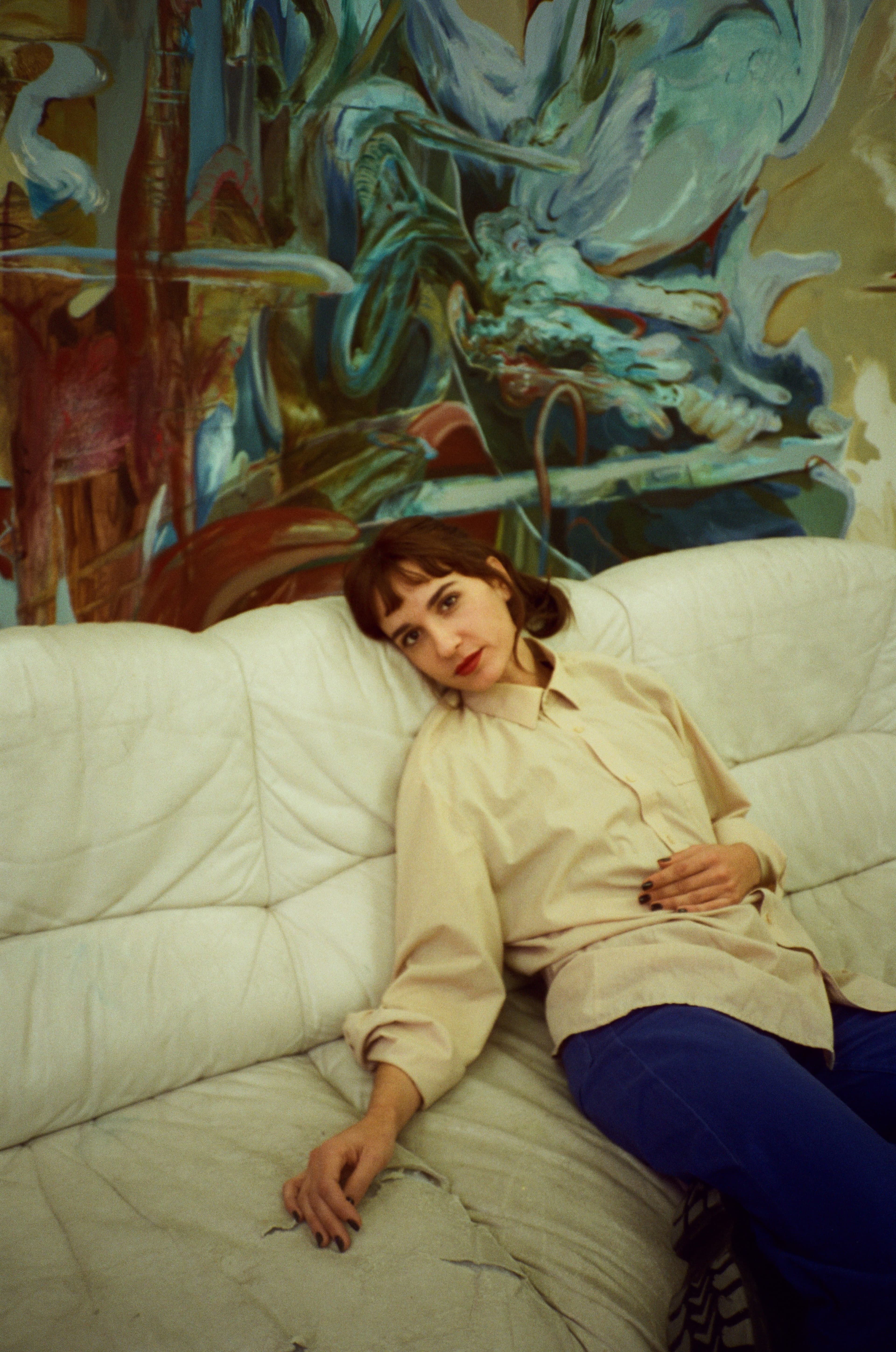 A portrait of Teresa Murta sat on a sofa