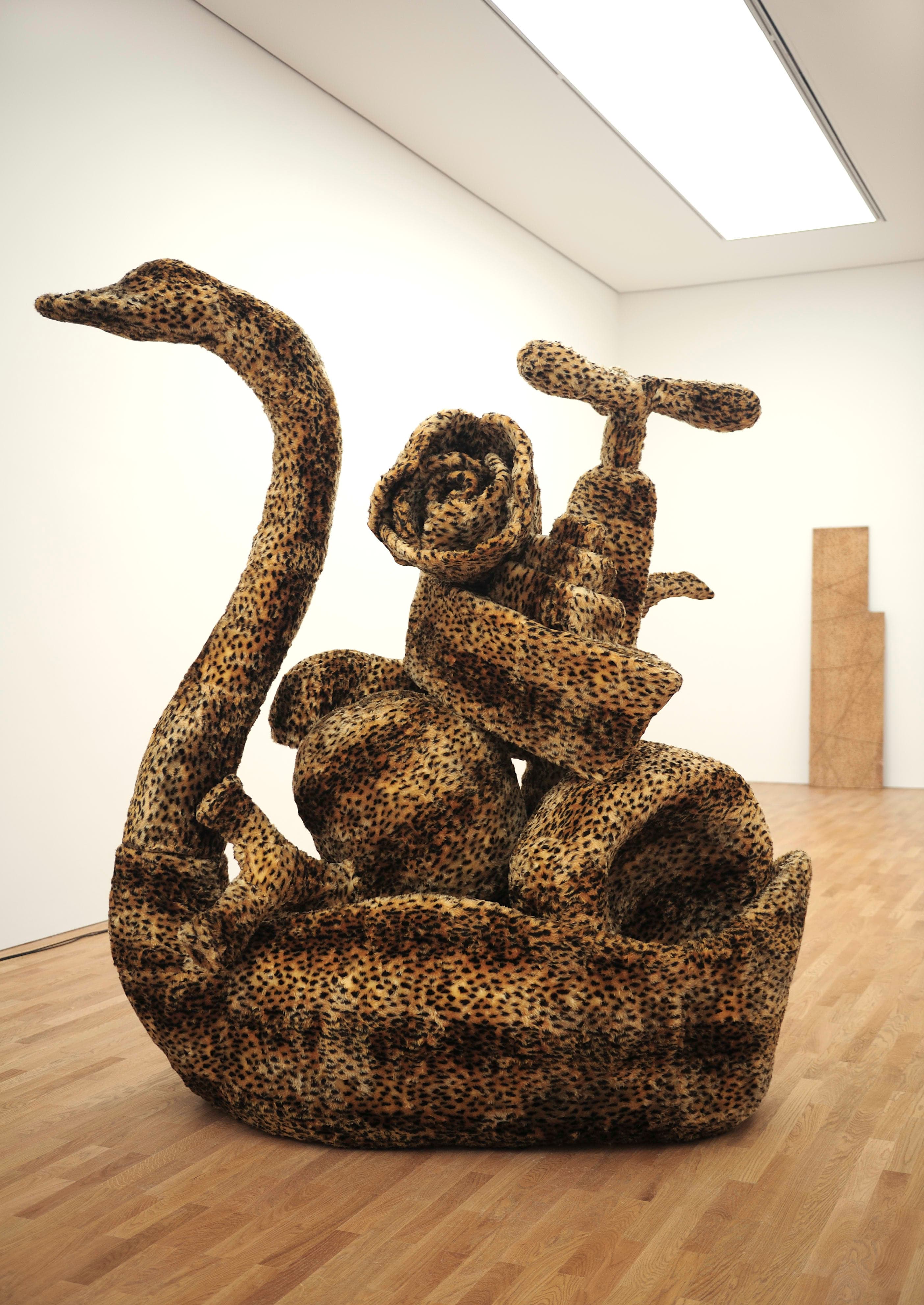 A sculpture by Eric Bainbridge of a scaled up swan dish filled with household objects and organs and covered in fake ocelot fur