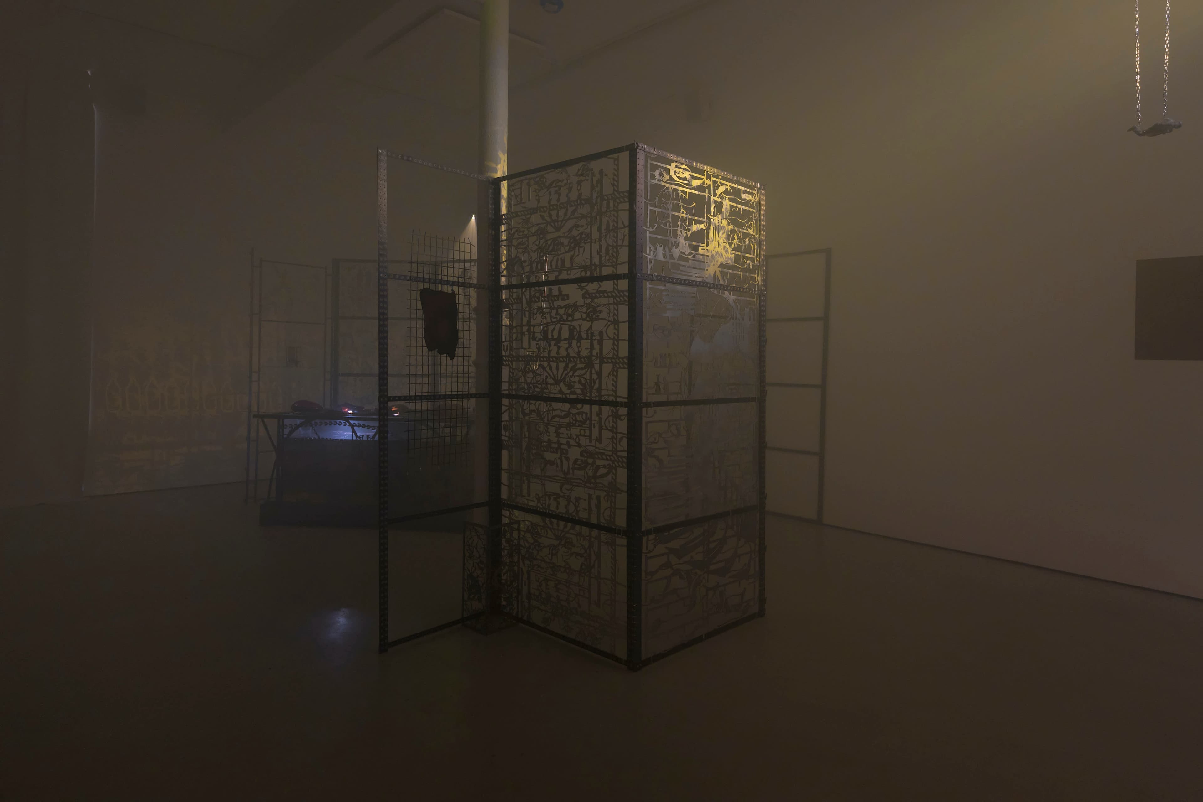 An installation by Hazel Brill including a water tanks filled with a dark liquid laser cut steel dividers, mouth-blown glass objects, projections and lights