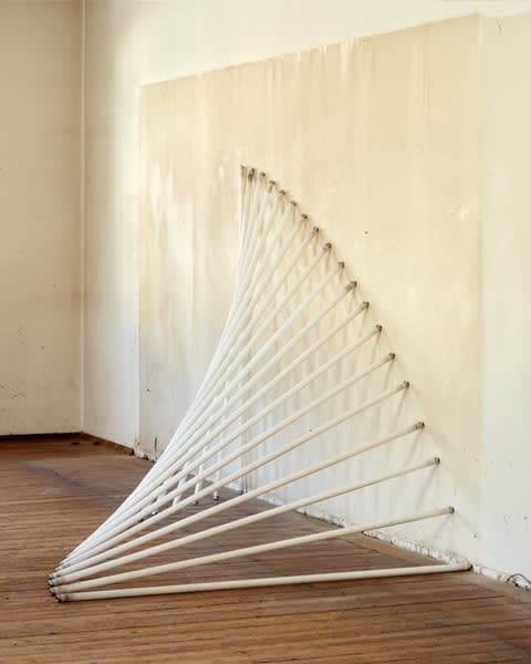 A sculpture by Jacob Dahlgren of a series of fluorescent tubes propped against the wall creating the illusion of a wave