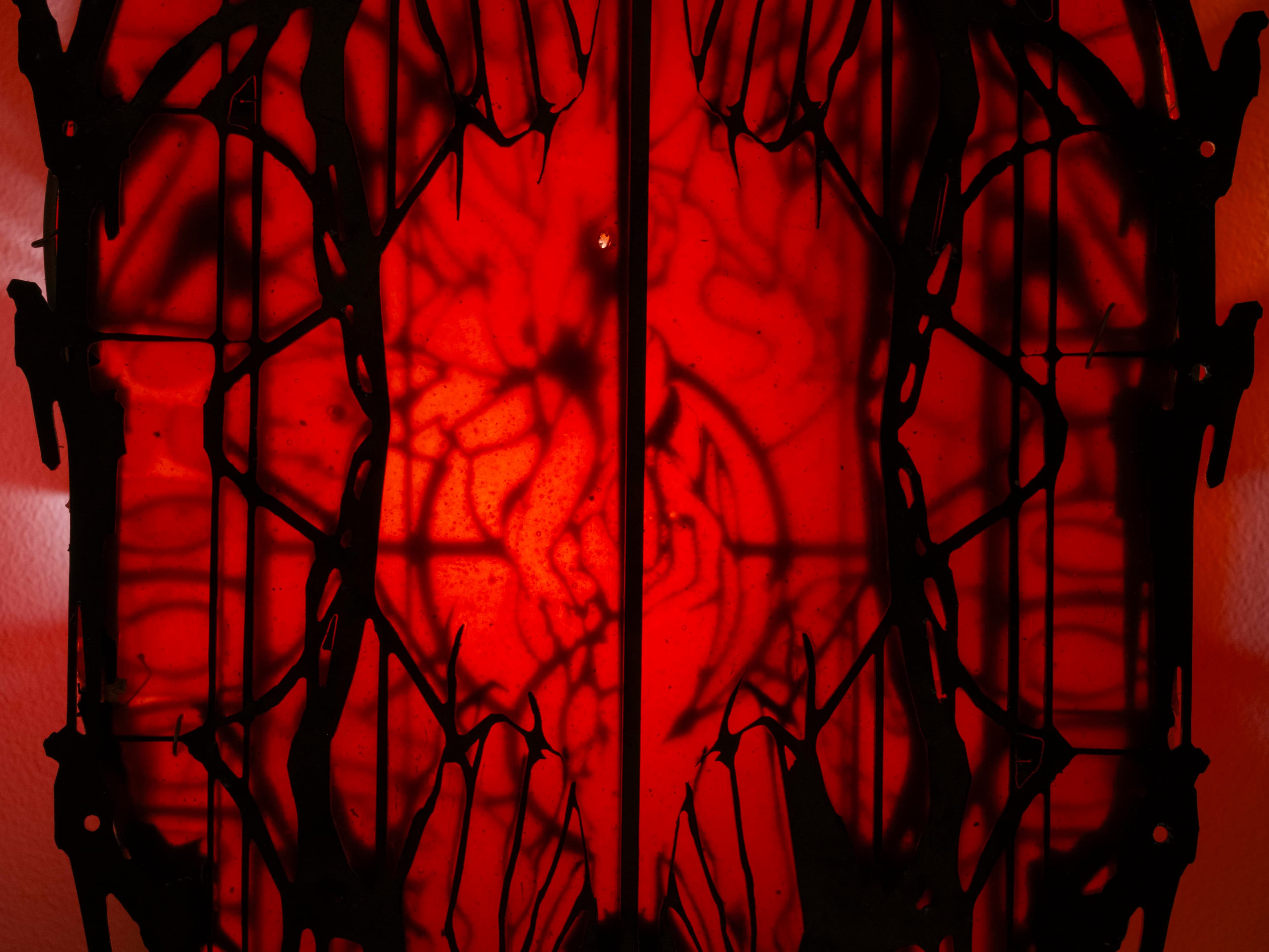 Wall sculpture by Hazel Brill made of a metal frame and latex skin and lit from the inside with a dim red light. Gothic in style.