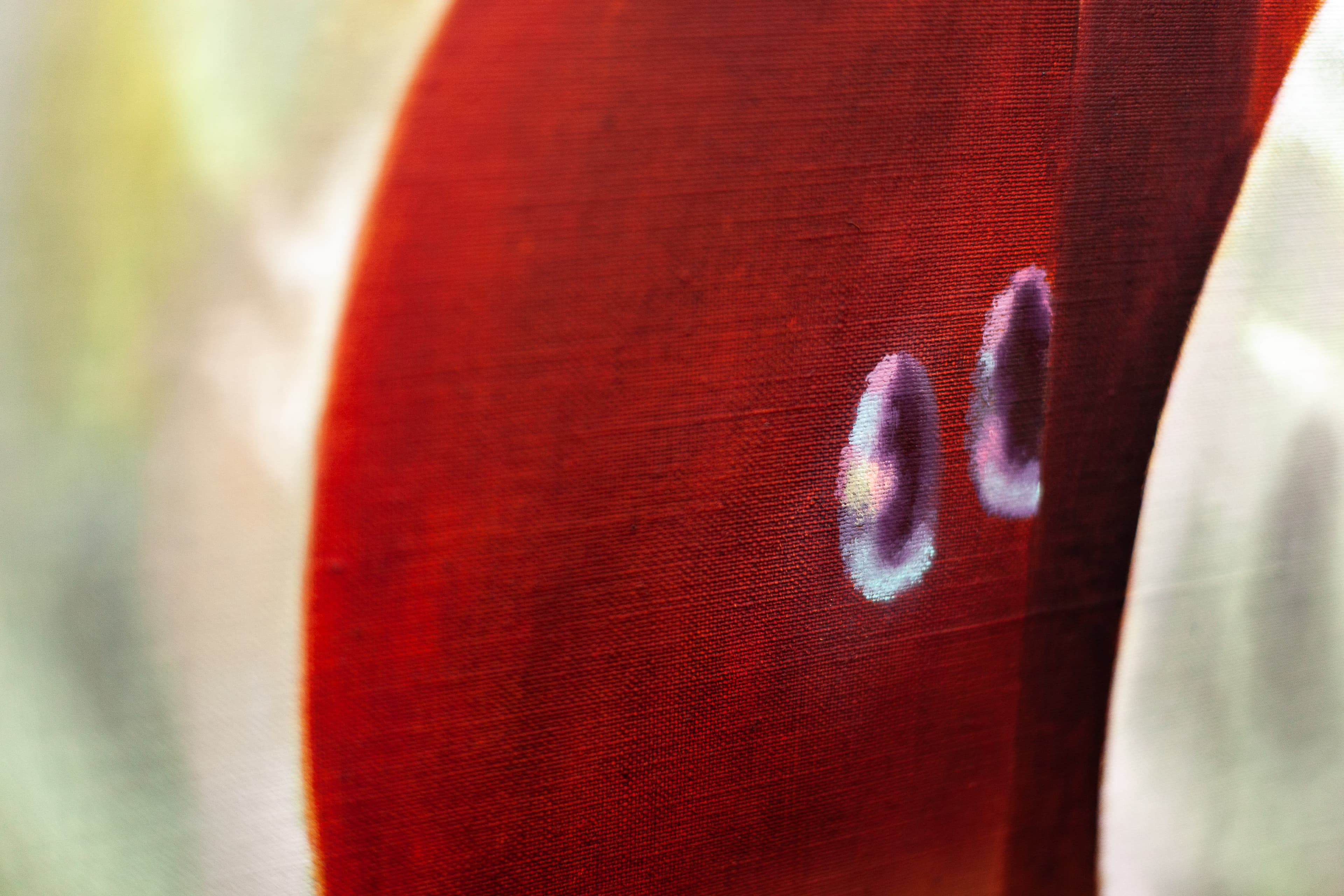 A painting by Robin Megannity of a silver metallic apple with a red core being cut half by a silver knife