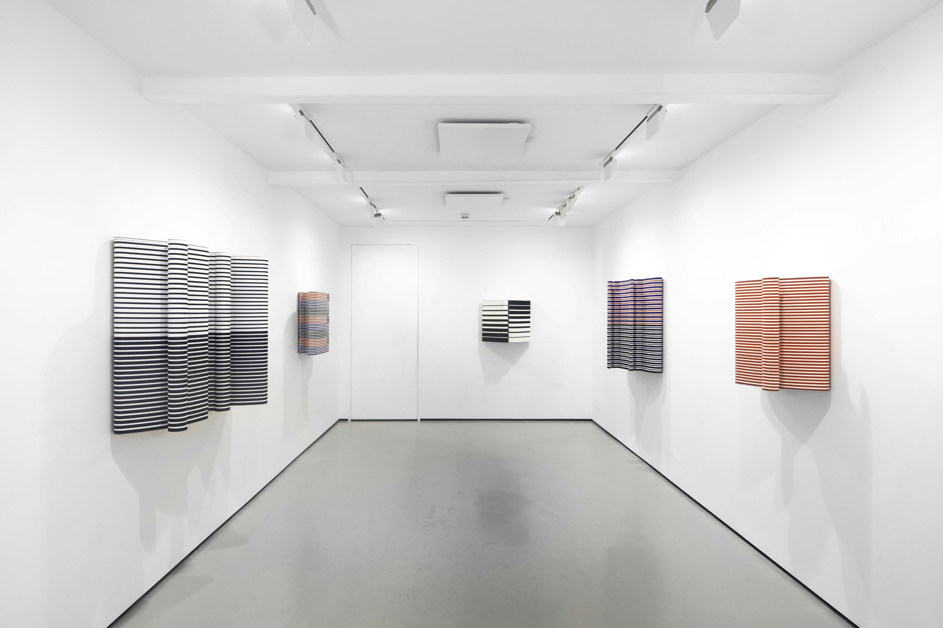 An installation view of Jacob Dahlgren's wall based sculptures made from coloured coat hangers 