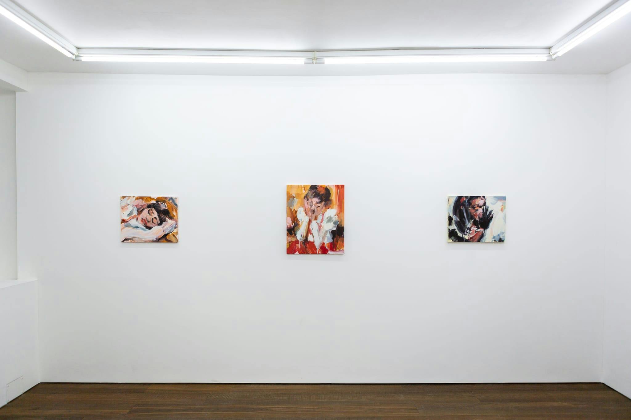 Installation shots of Laura Lancaster's solo show at Workplace London. Close up crop paintings of sleeping women and figures in landscapes, loosely painted.
