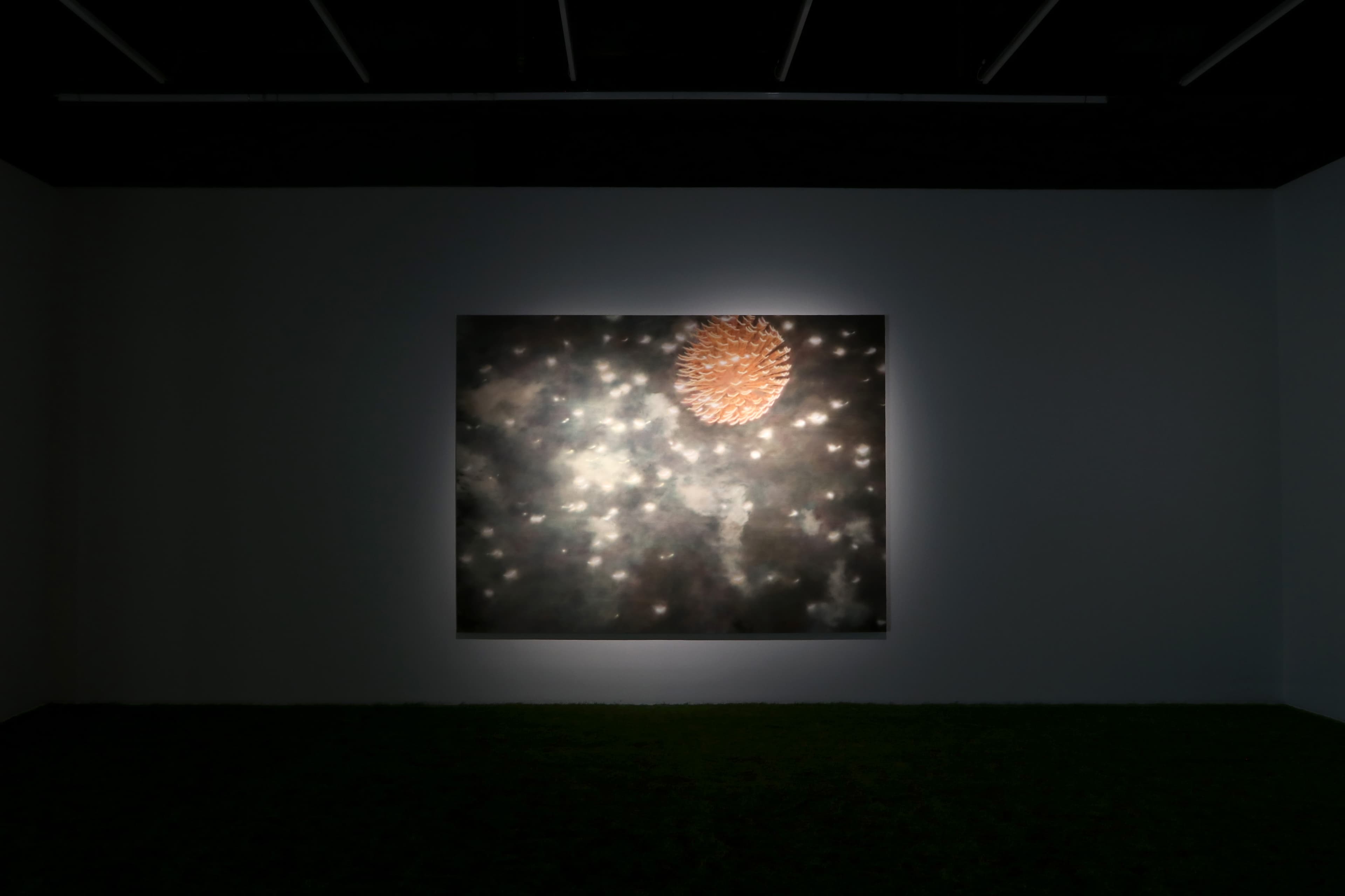 Installation view of a dark room with a painting by James Prapaithong softly spotlit