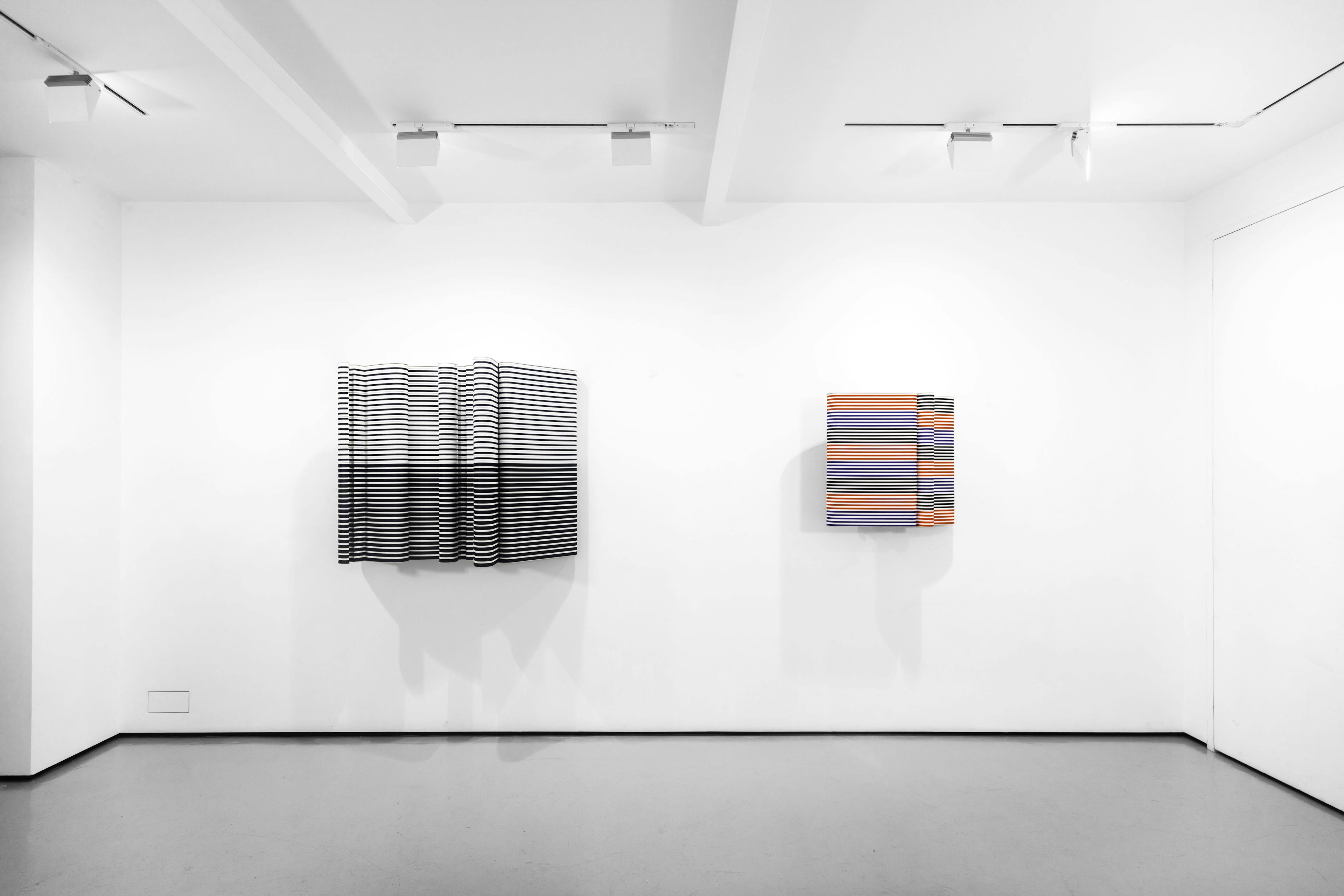 An installation view of Jacob Dahlgren's wall based sculptures made from coloured coat hangers 