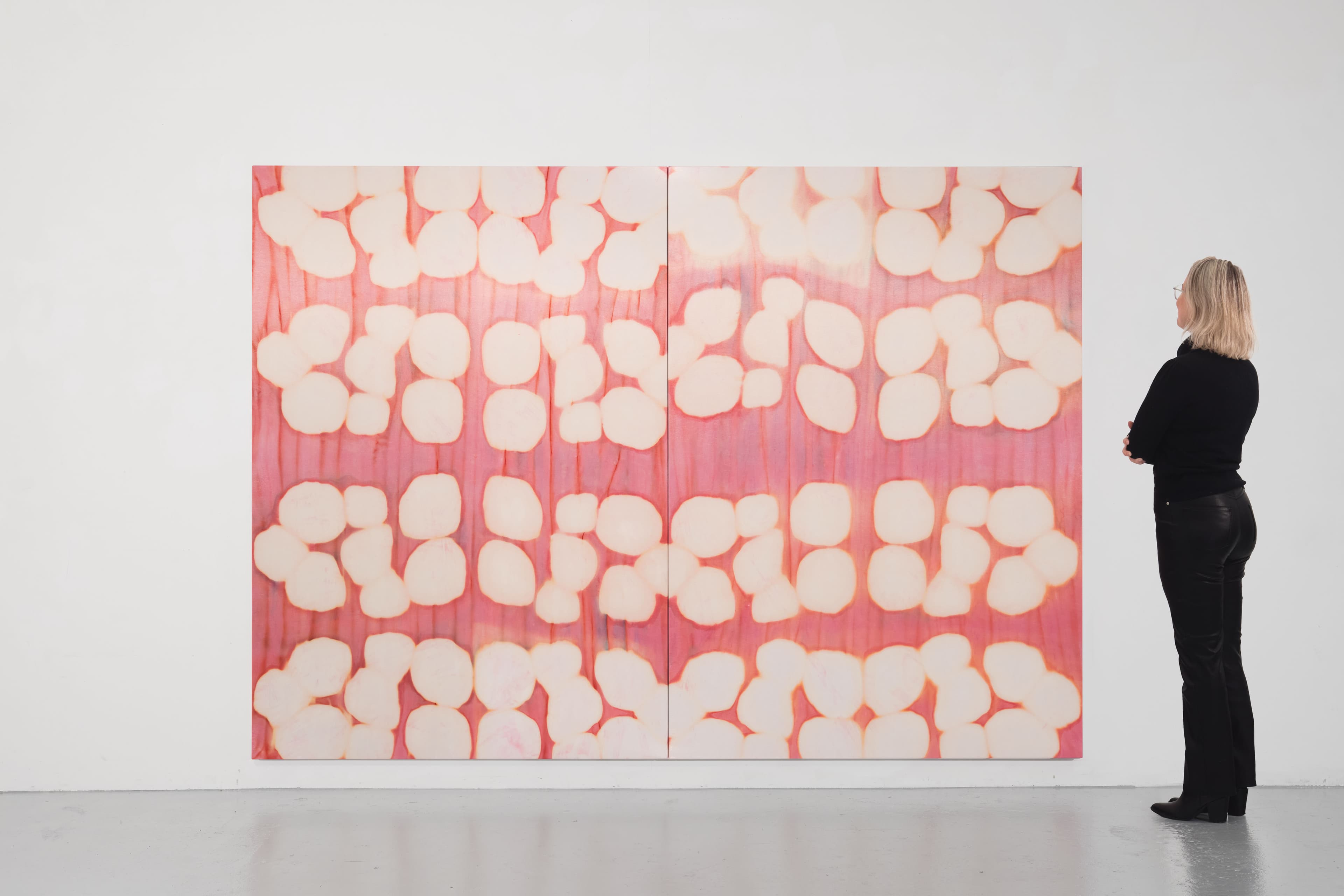 A large diptych painting by Max Boyla. Circular white forms on a pink background.