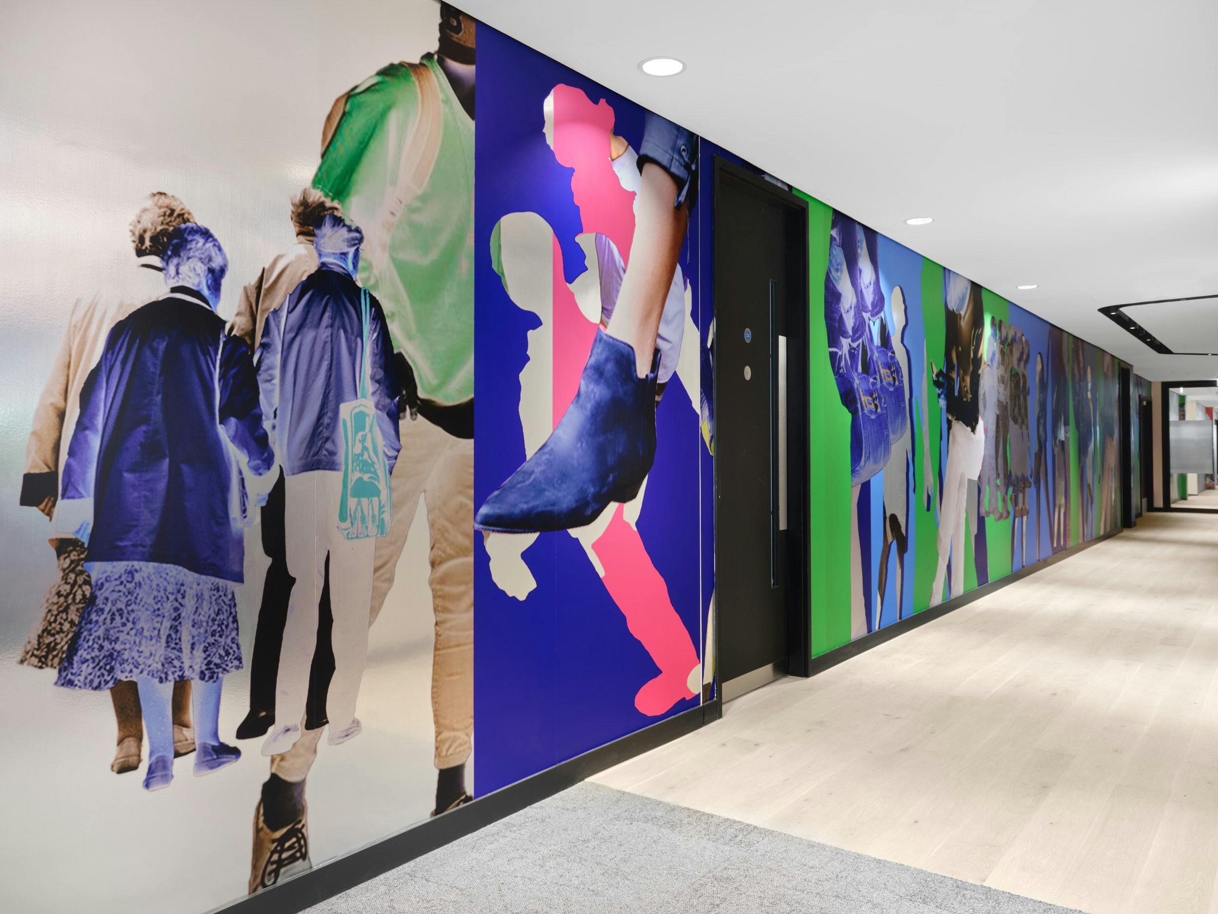 An installation by Simeon Barclay in an office composed of bright collaged people standing and walking