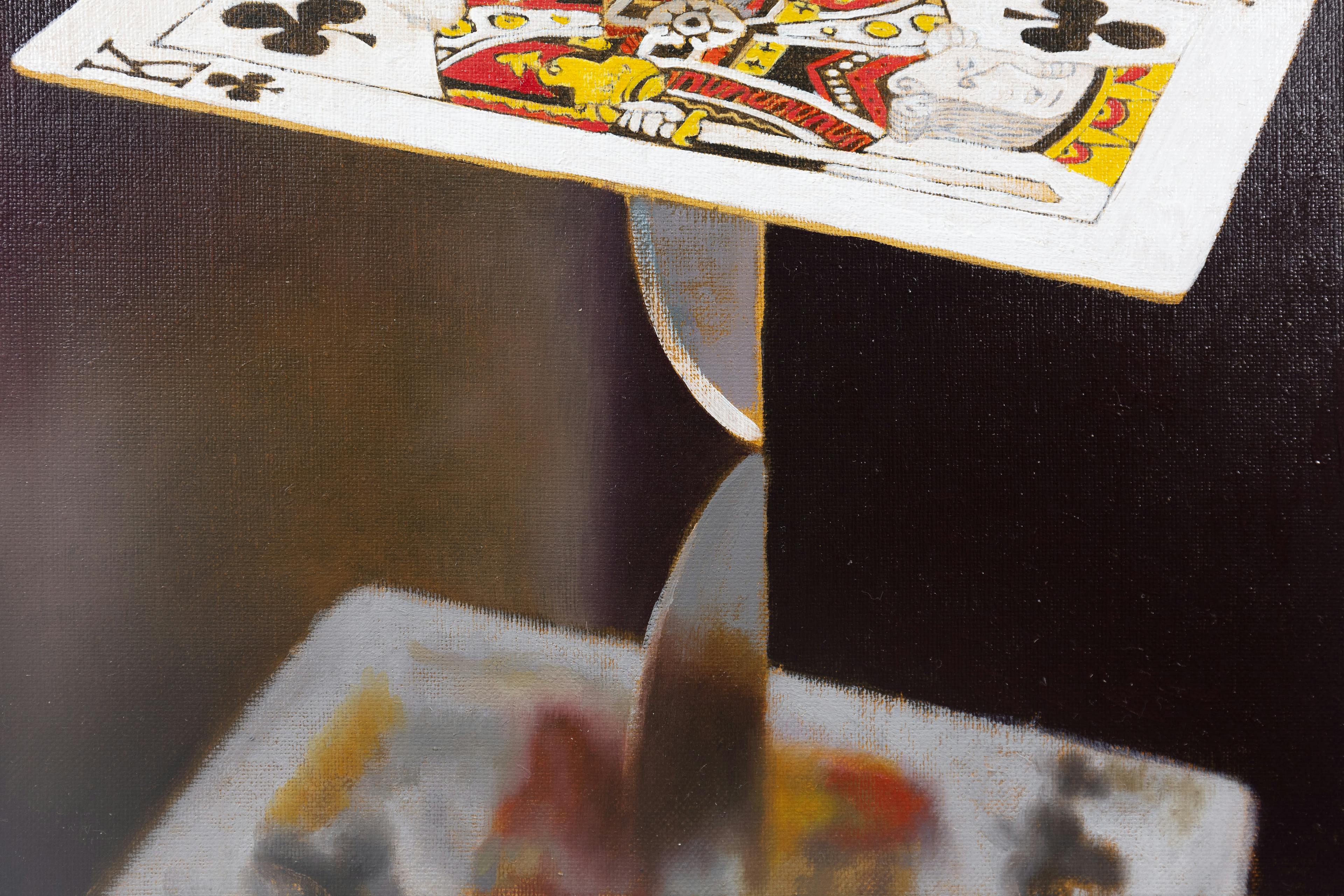 a dagger pierces a king of clubs card above a mirrored surface