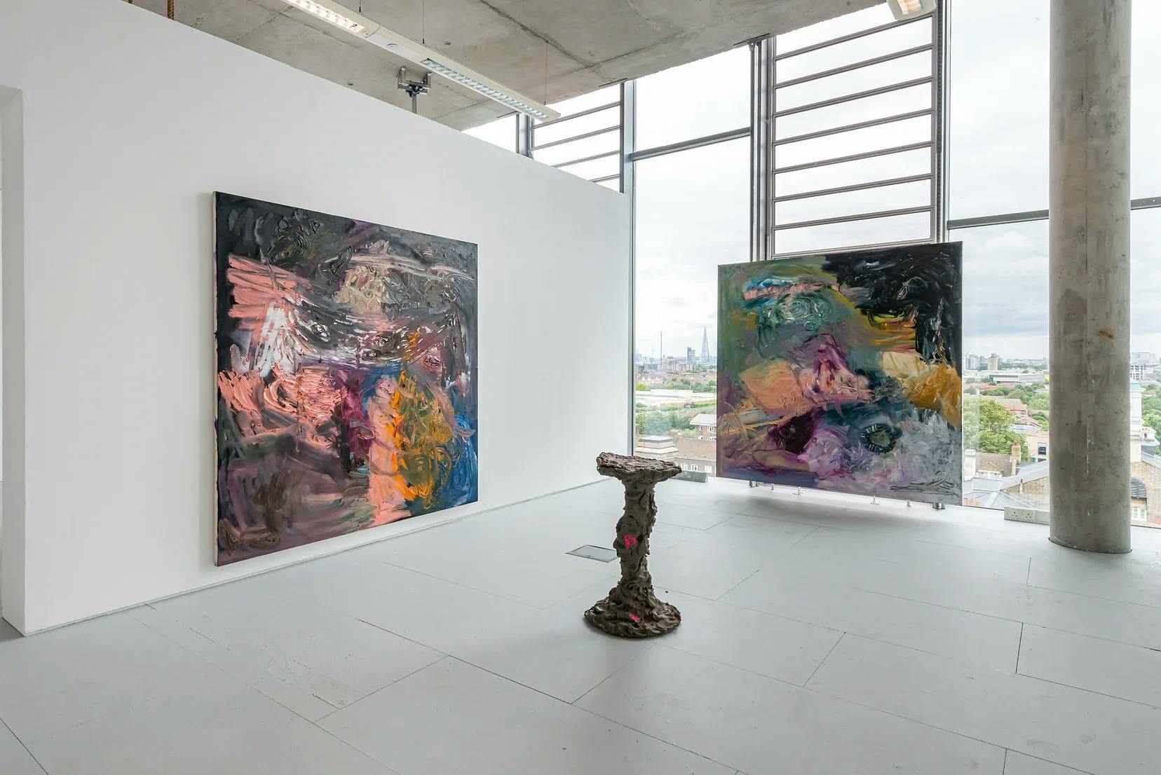 An installation by James Cabaniuk of 2 large abstract paintings and a clay sculpture on the floor