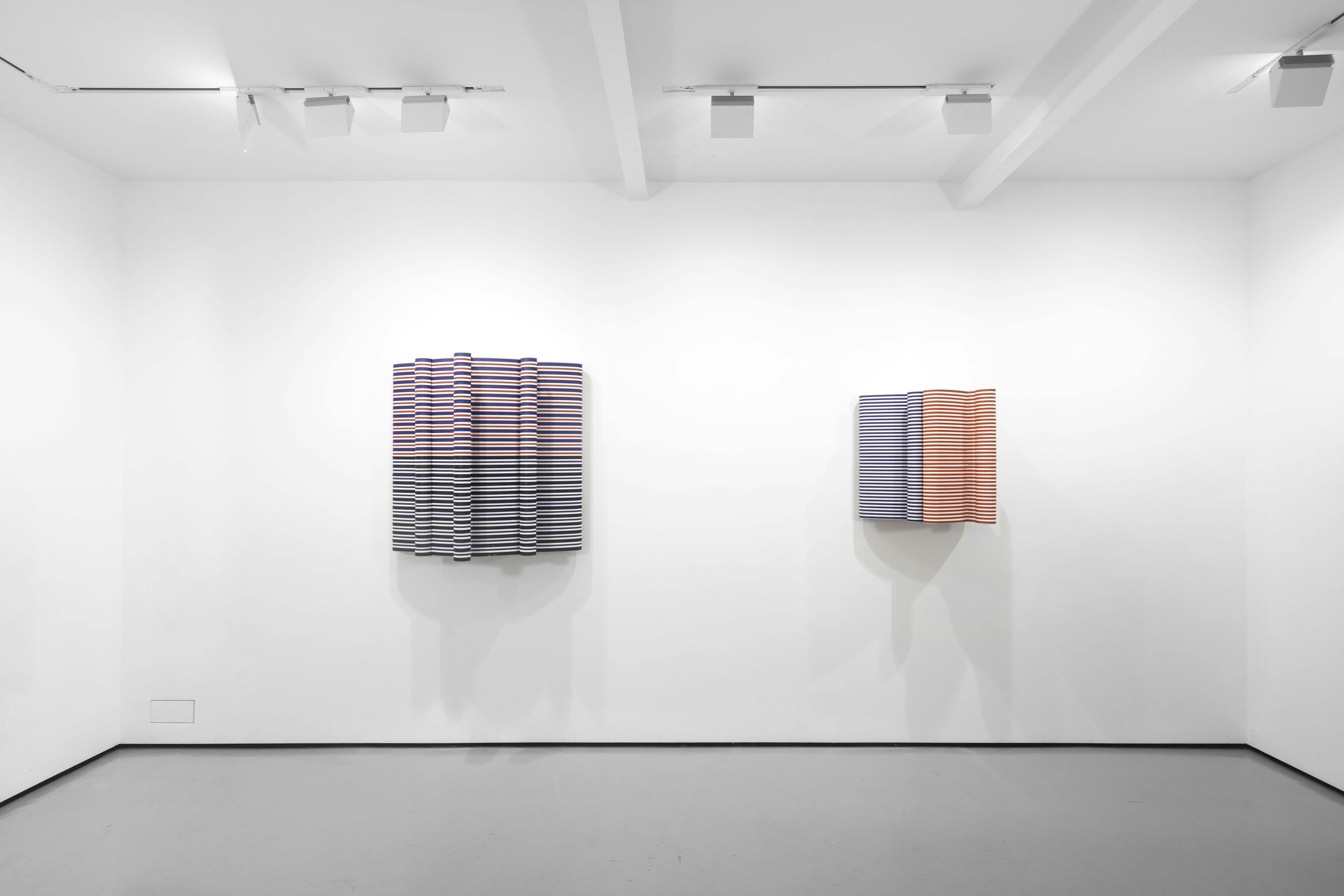 An installation view of Jacob Dahlgren's wall based sculptures made from coloured coat hangers 