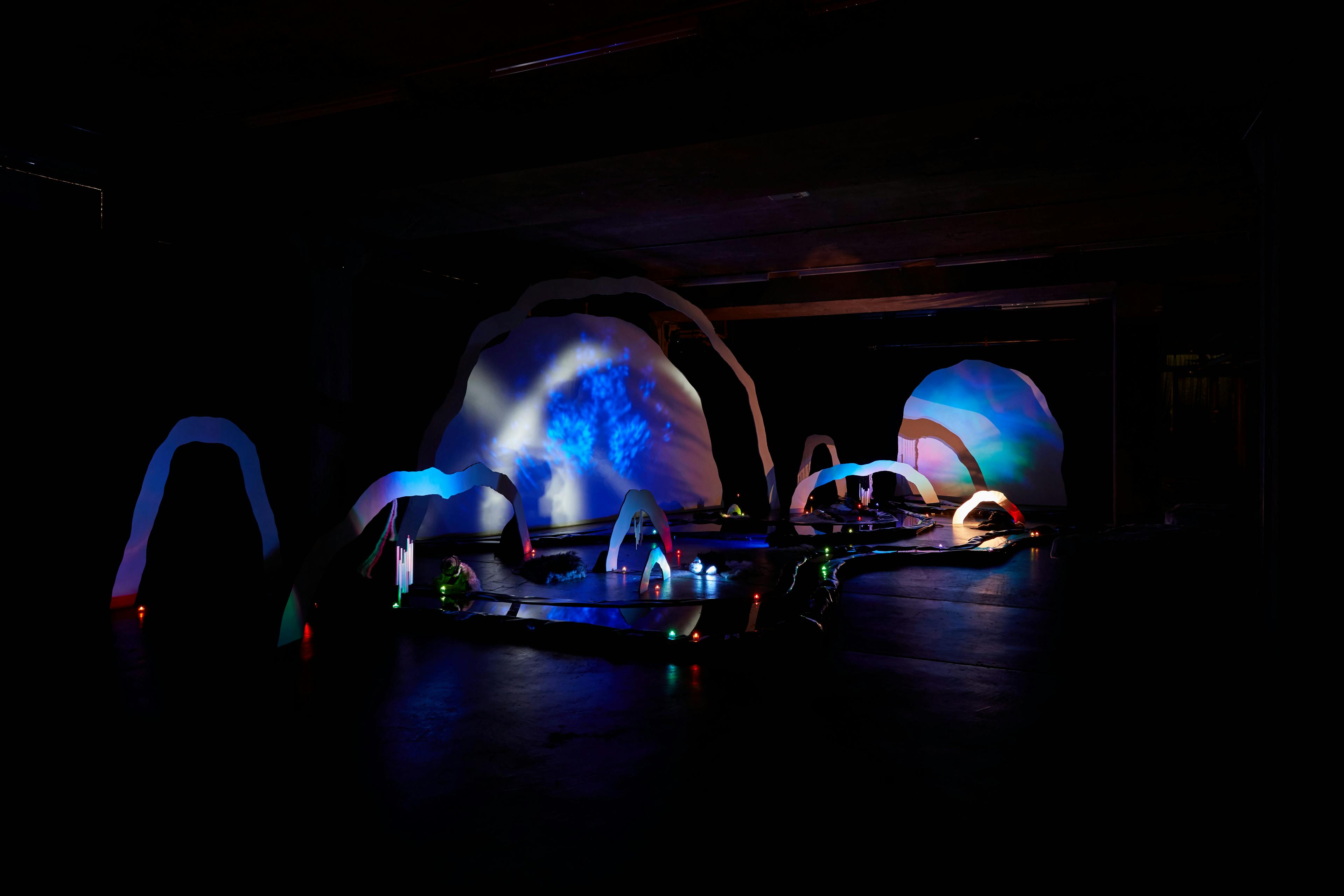 An installation by Hazel Brill of a number of amorphous forms with abstracted imagery projected onto them 