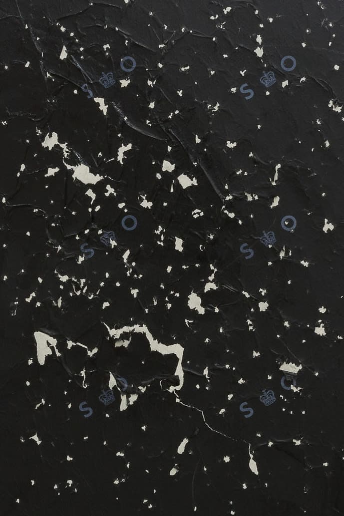 A crop of a painting by Jennifer Douglas made with carbon copy paper on grey floor paint. An insignia from the post office Sorting Office reads 'S-O' 