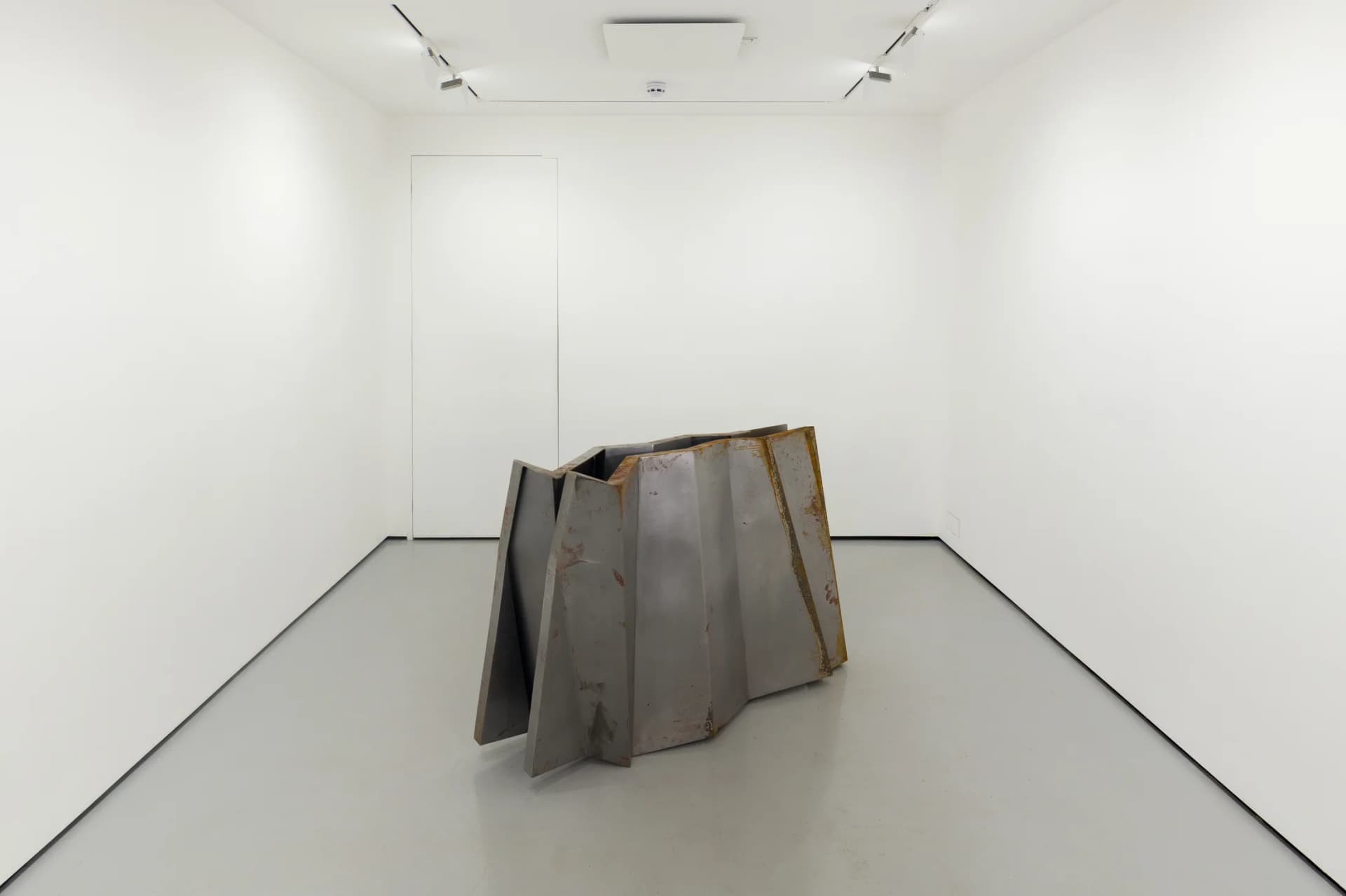 a steel sculpture by Hannah Perry with 2 walls in a ziggurat shape slightly apart from each other