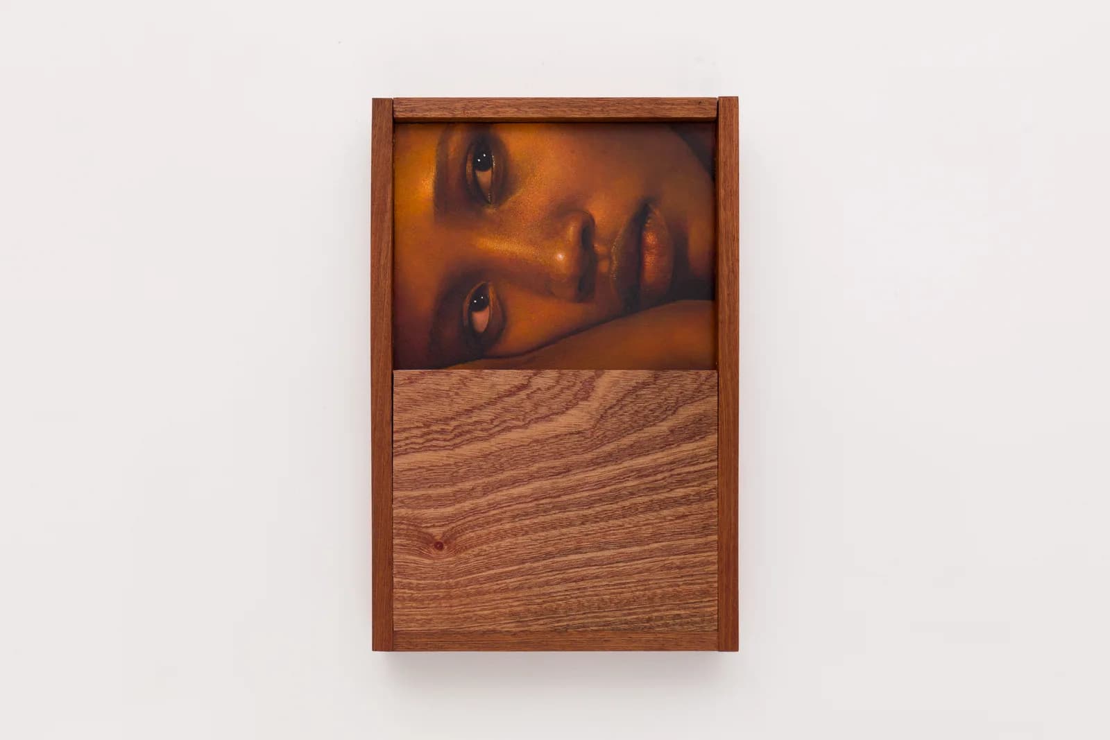 A close-cropped oil on board portrait by Ki Yoong of a young Black woman lying on her side, incorporating a hardwood frame and lower panel
