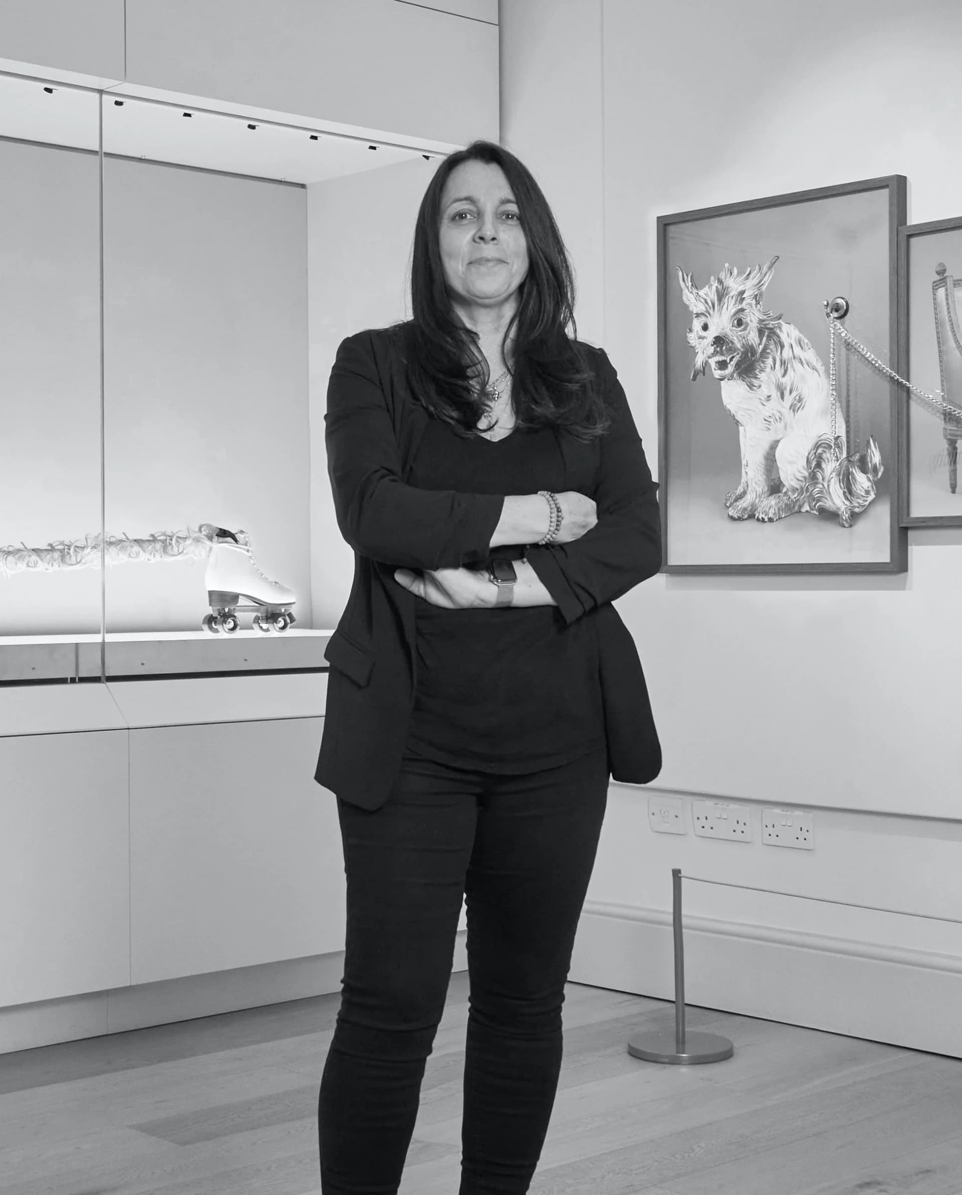 A black and white portrait of artist Maria Meyer stood in her exhibition